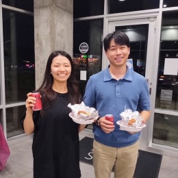 a couple holding food and drinks