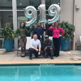 people holding balloons by a pool